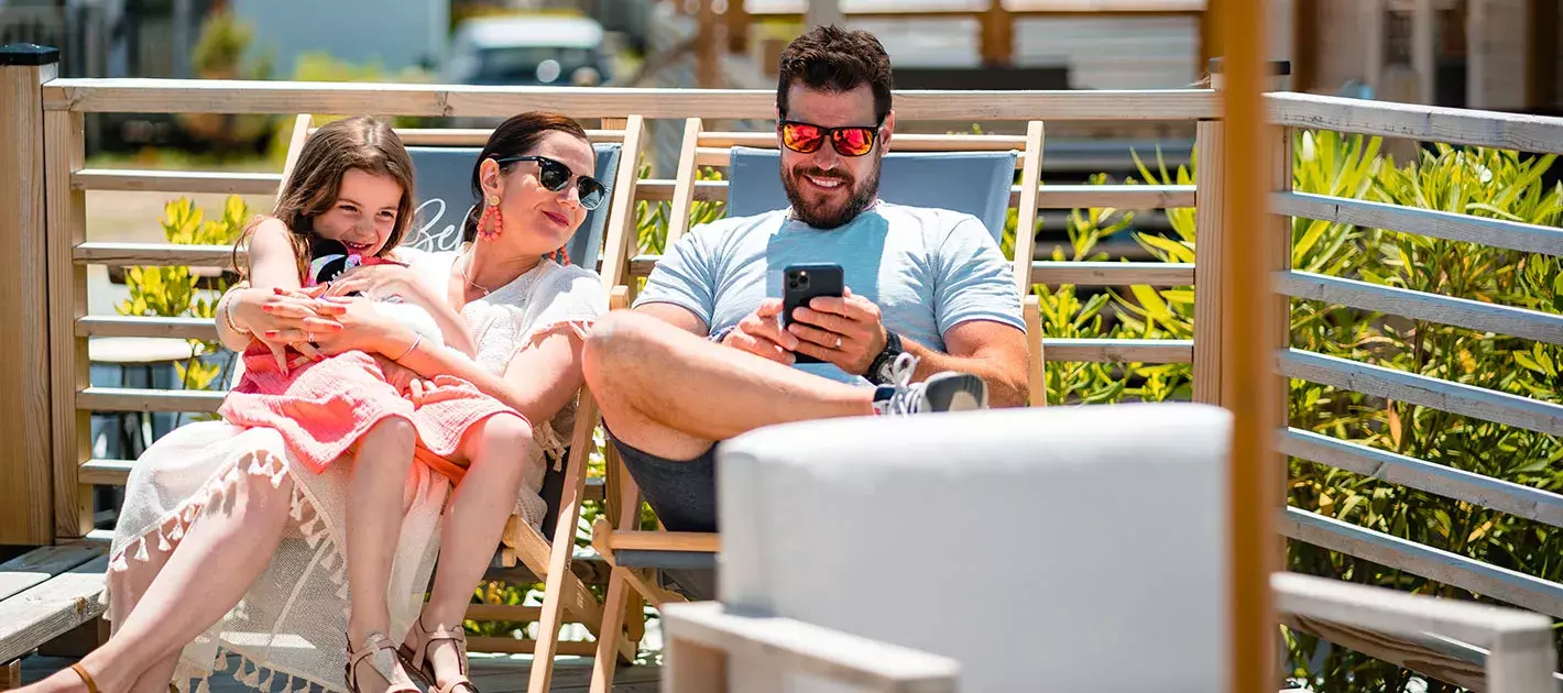 Famille sur des transats sur une terrasse de mobil home